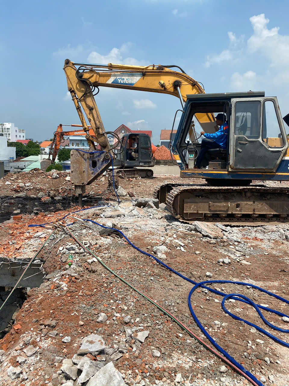 Hai xe cơ giới xử lý kết cấu tại công trình phá dỡ trong khu dân cư
