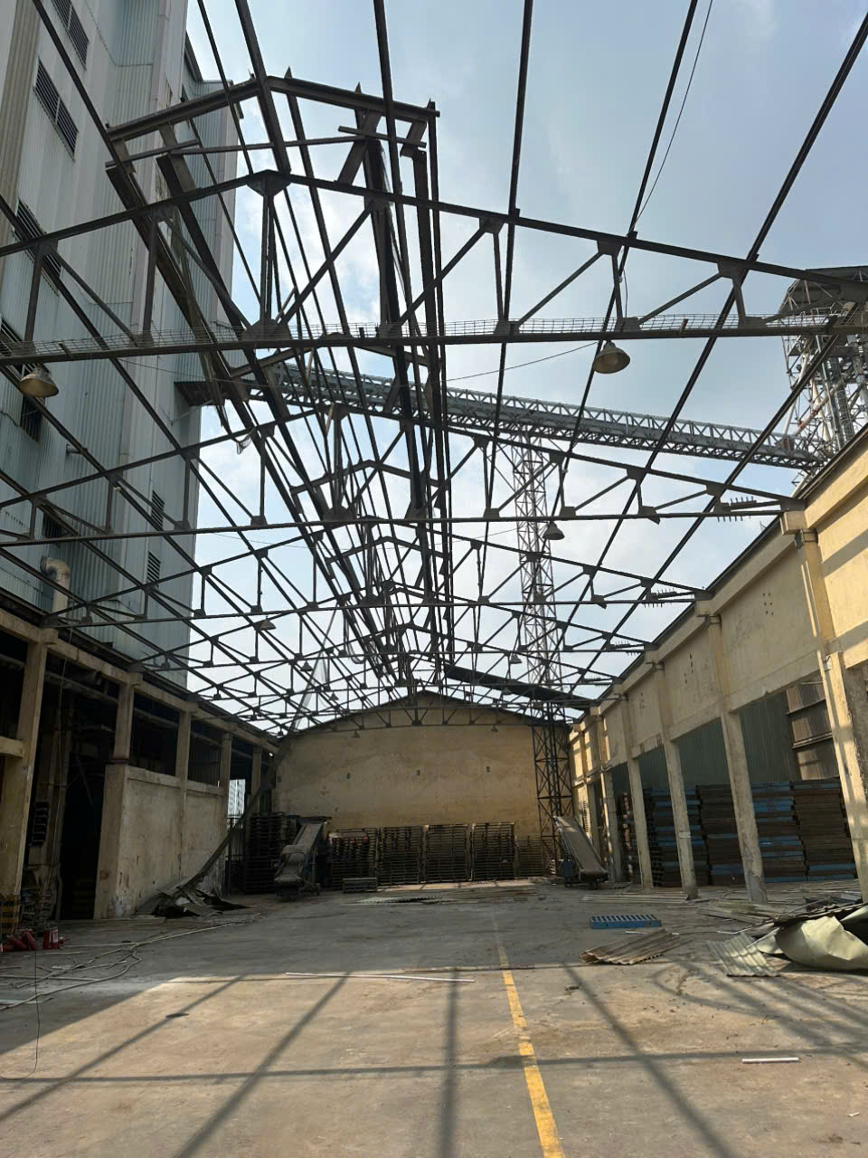 Khung kèo thép nhà xưởng đã tháo một phần mái tôn, để lộ khung xương thép bên trên