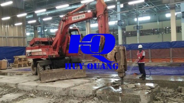 Máy xúc gắn đầu đục thủy lực thi công bên trong nhà xưởng