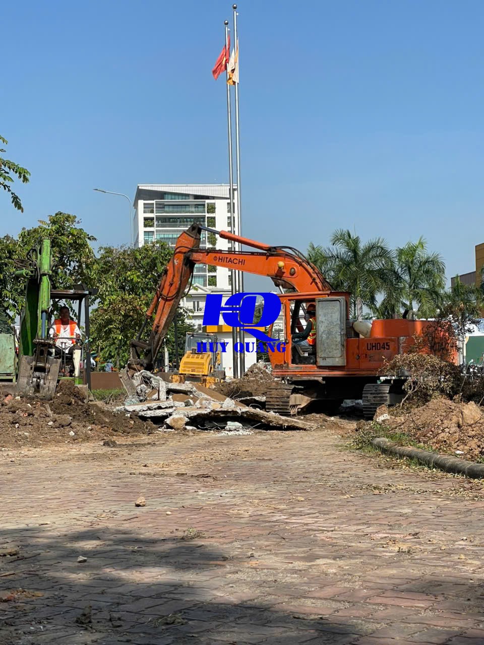 Máy xúc Hitachi xử lý mặt bằng cạnh khu vực dân cư