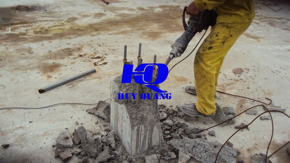 Công nhân dùng máy khoan đục phá cột bê tông cốt thép tại công trình nhà xưởng công nghiệp