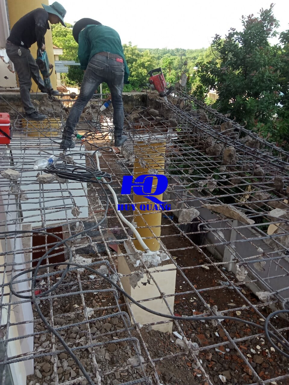 Công nhân xử lý hệ khung sắt mái còn lại tại công trình, kiểm tra kết cấu trước khi tháo dỡ tiếp