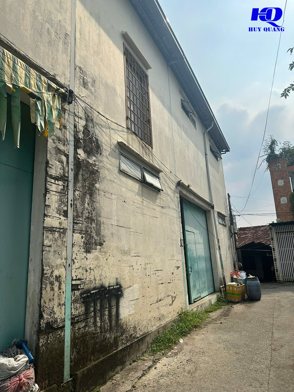 Mặt ngoài nhà dân tường cũ bong tróc cạnh hẻm bê tông tại Đồng Xoài, Bình Phước, trước khi phá dỡ