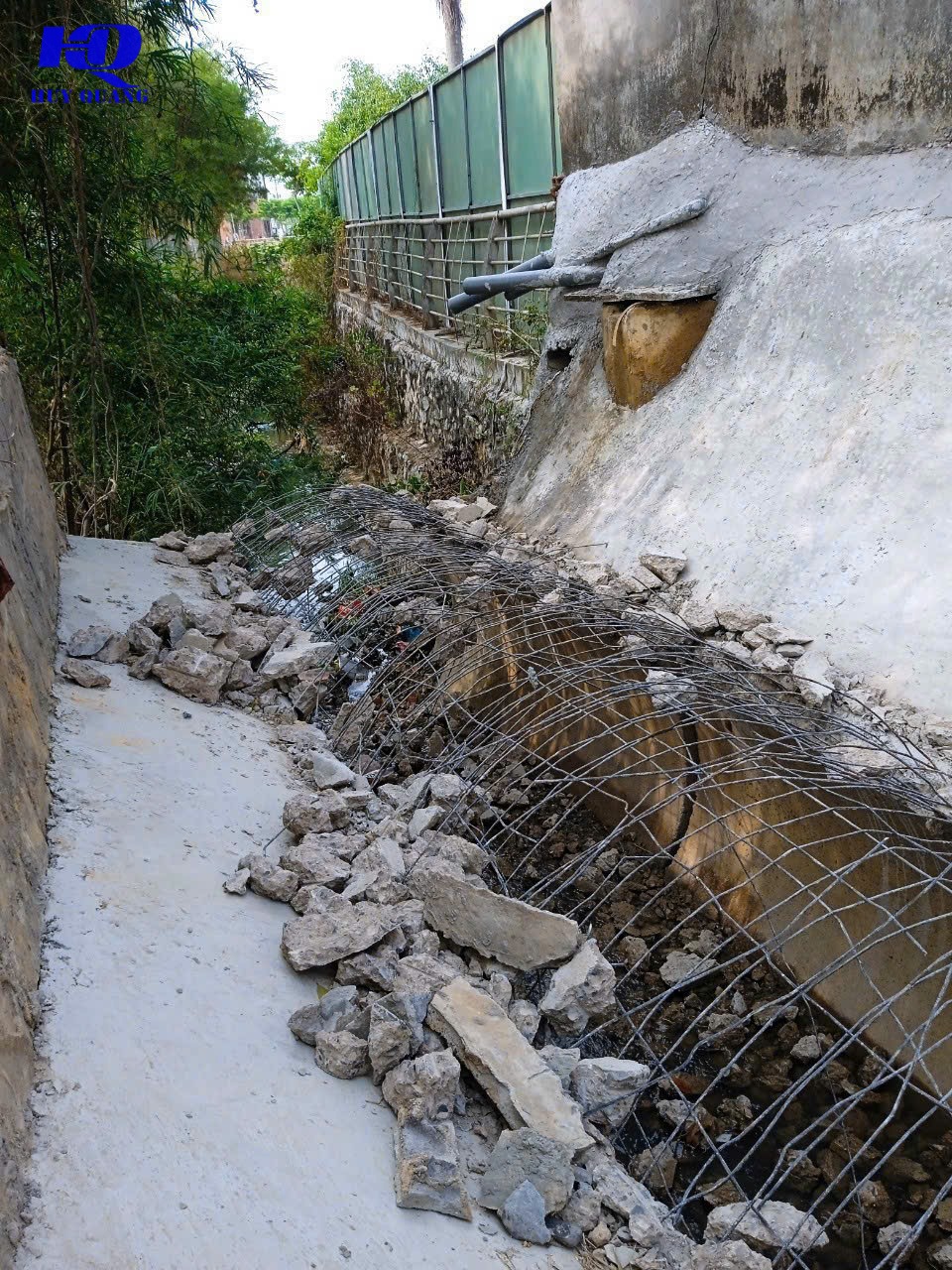 Đục bỏ đoạn mương thoát nước bê tông cũ dọc lối đi dân cư, khung cốt thép uốn cong dựng sẵn cho đoạn cống mới, bê tông vỡ dồn dọc lối đi hẹp
