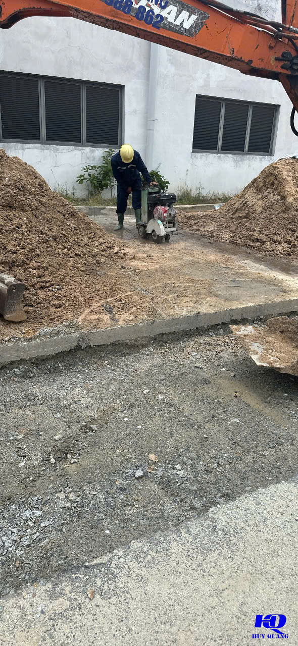 Thợ vận hành máy cắt bê tông cầm tay cắt rãnh kỹ thuật dọc tường nhà xưởng tại KCN Bàu Bàng mở rộng, Lai Uyên, Bình Dương