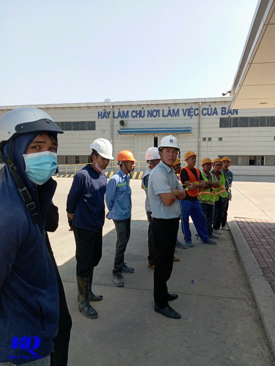 Đội thi công Huy Quang tập trung điểm danh, trang bị mũ bảo hộ và áo phản quang trước khi vào thi công nhà xưởng trong khu công nghiệp